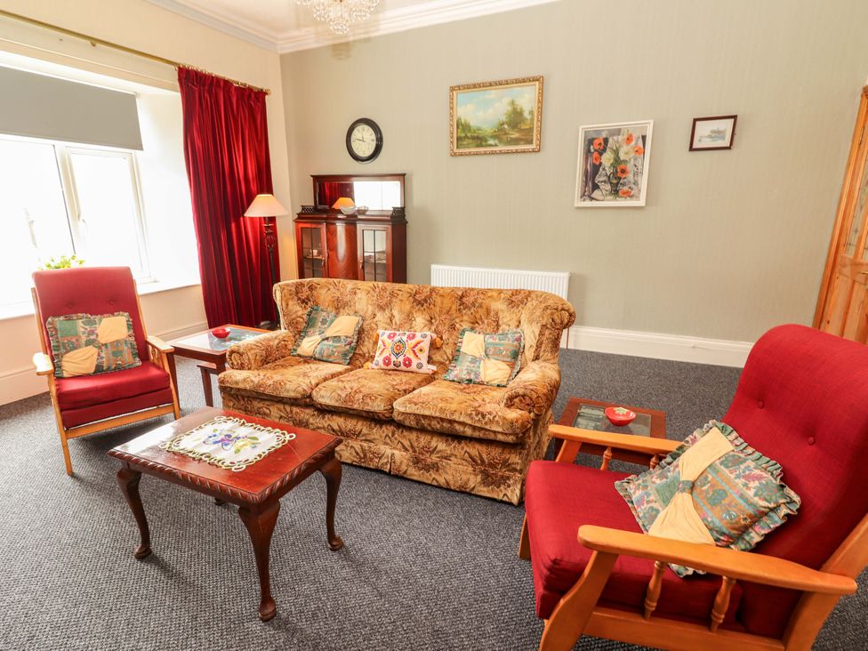 A living room with a sofa and armchairs at Macmathuna in Kilrush, County Clare