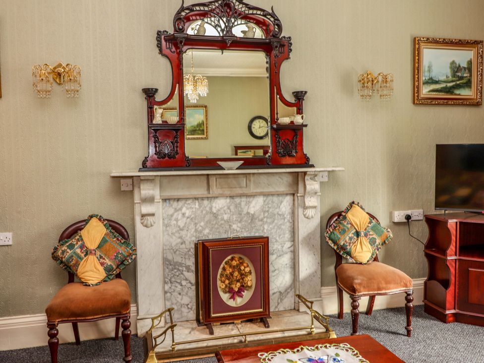 A living room with a fireplace and mirror at Macmathuna Kilrush, County Clare