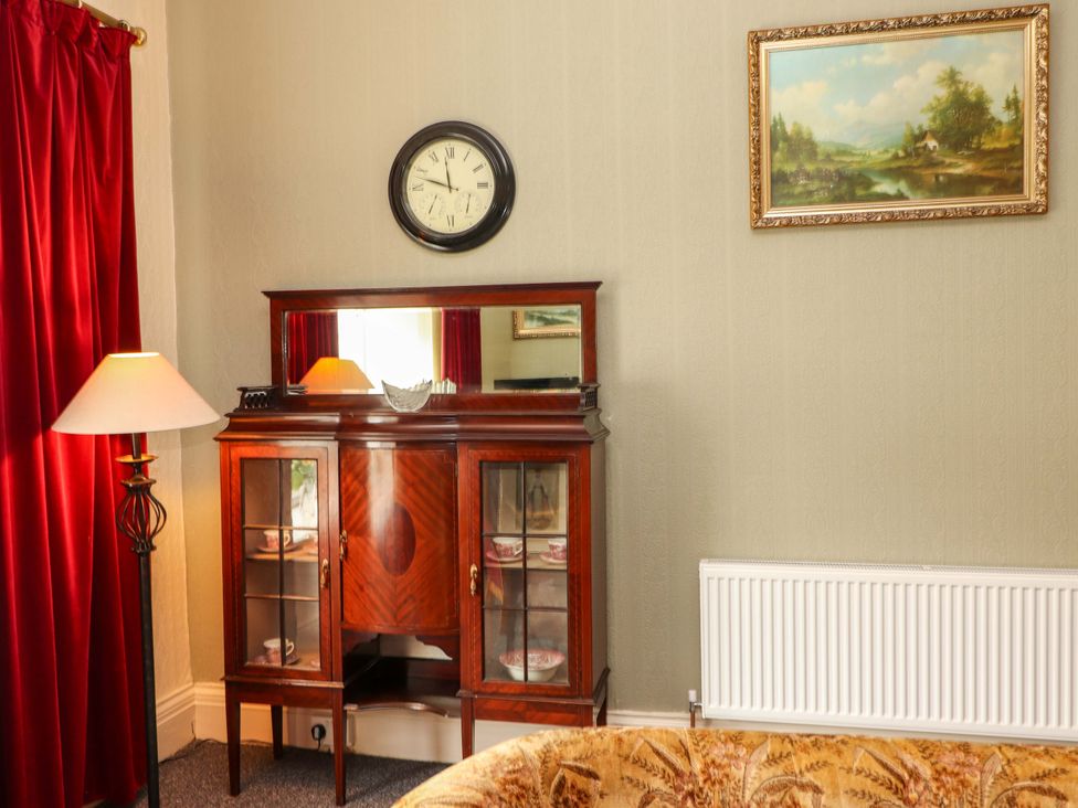 A living room with a mirror and cabinet at Macmathuna in Kilrush, County Clare