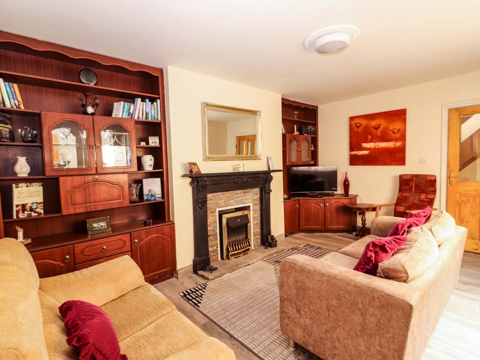 A living room with a fireplace and bookshelf at Macmathuna in Kilrush, County Clare