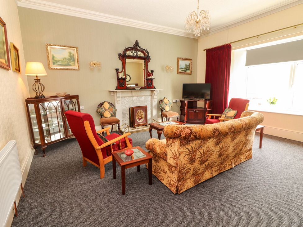 A living room with a sofa and armchairs at Macmathuna, Kilrush, County Clare