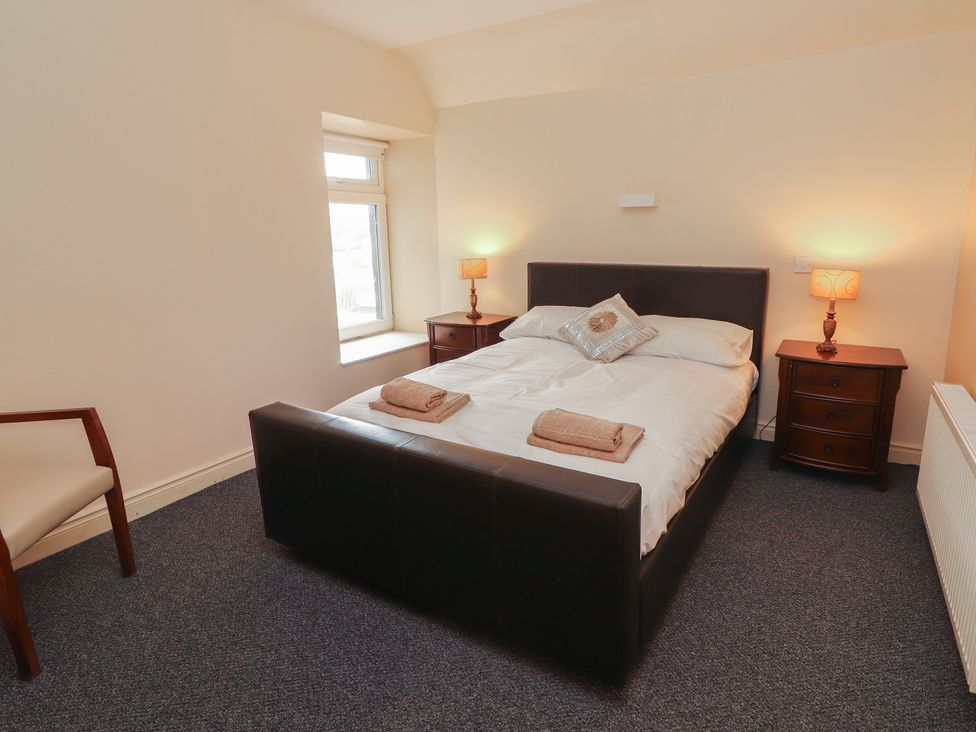 A bedroom with a bed and nightstands at Macmathuna in Kilrush, County Clare