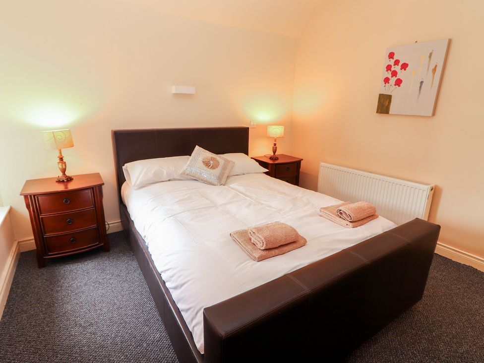 A bedroom with a bed and nightstands at Macmathuna in Kilrush, County Clare