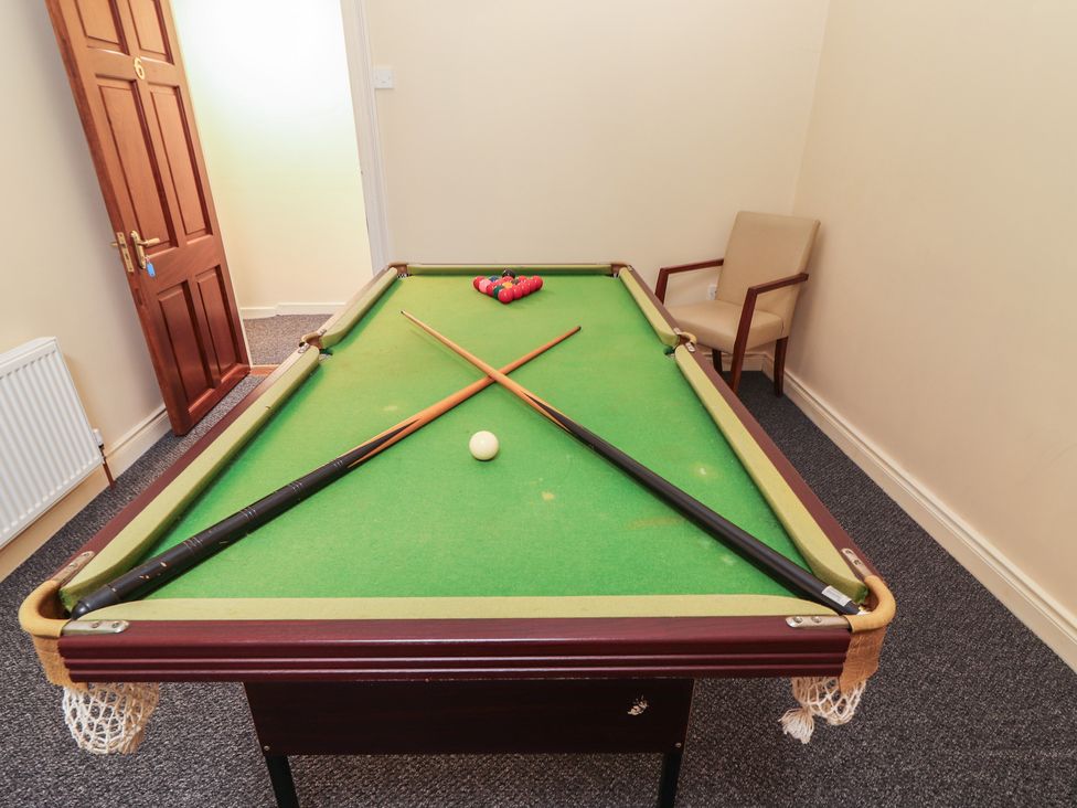 A game room with a pool table and cues at Macmathuna Kilrush, County Clare
