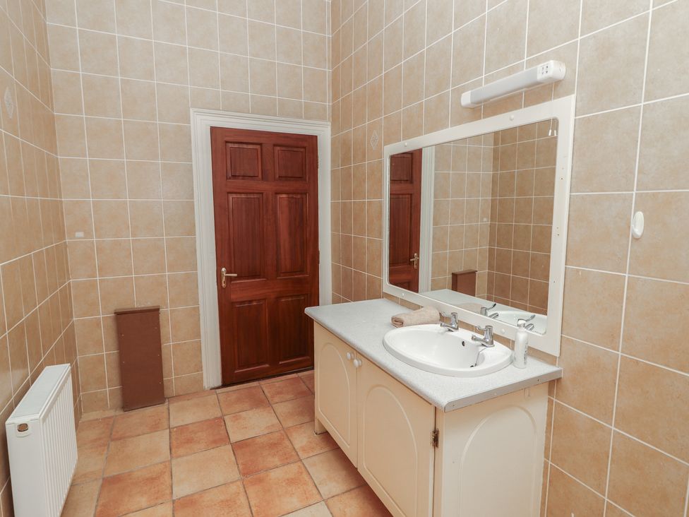 A bathroom with a sink and mirror at Macmathuna in Kilrush, County Clare