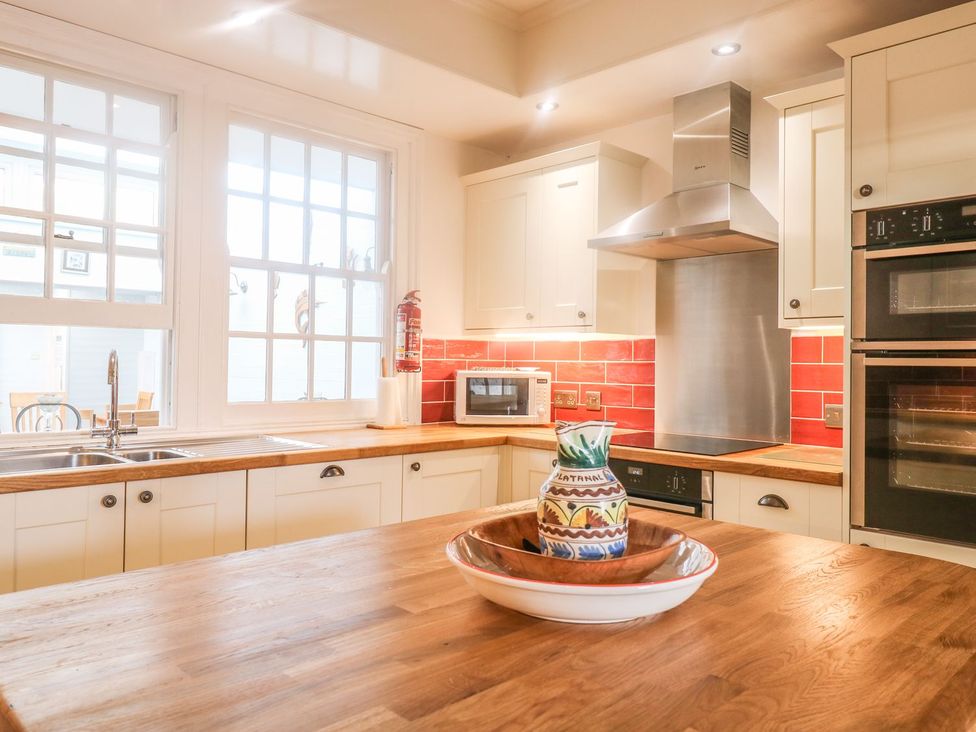 A kitchen with a sink, countertop, microwave, and ovens at The Old Bank House in Mevagissey