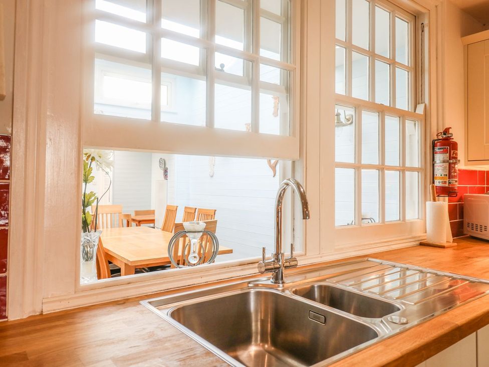 A kitchen featuring a sink and dining area at The Old Bank House in Mevagissey