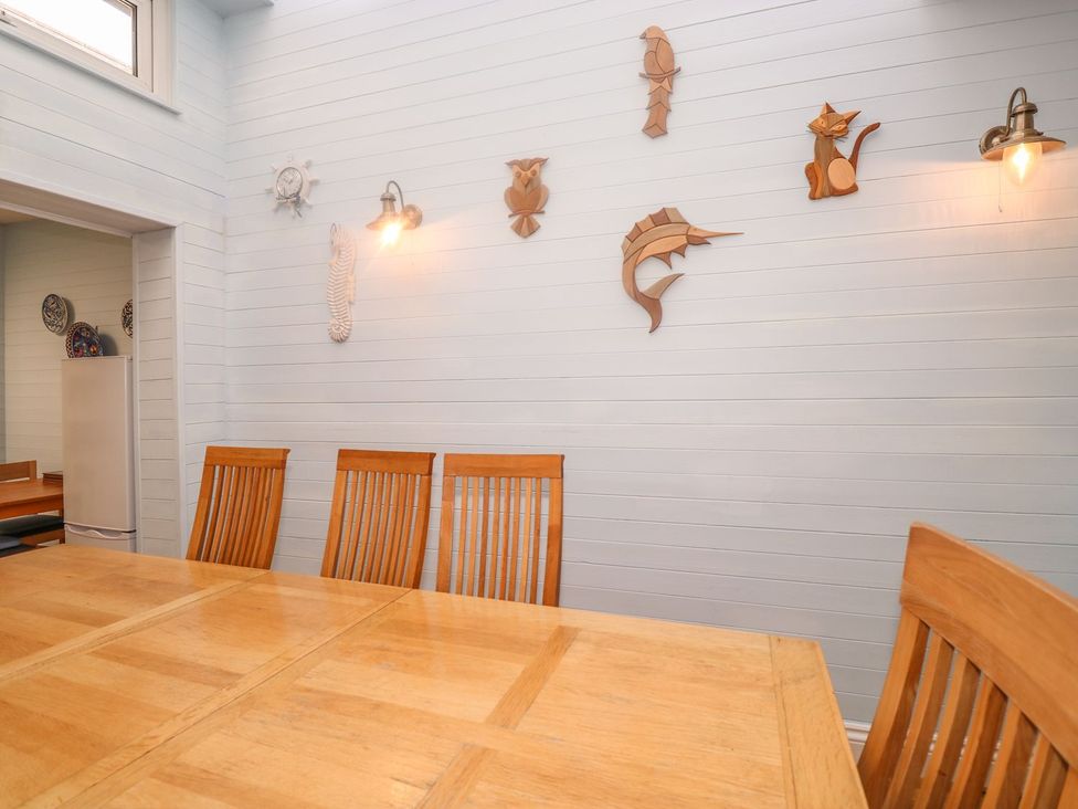 A dining room with a wooden table and chairs at The Old Bank House in Mevagissey