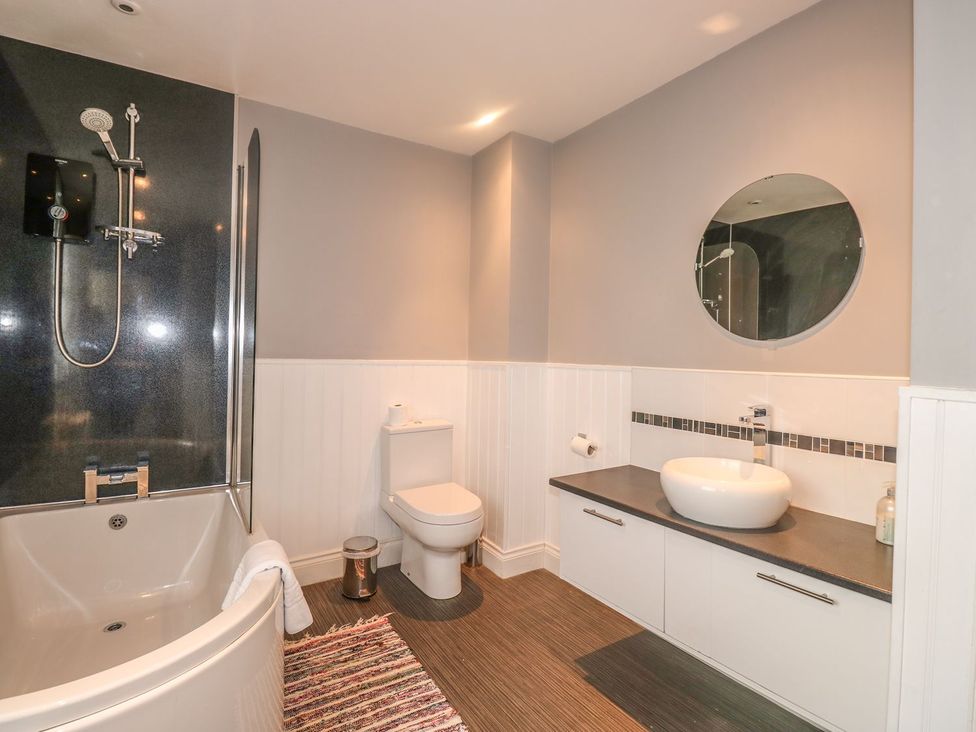 A bathroom with a bathtub, toilet, and sink at The Old Bank House in Mevagissey