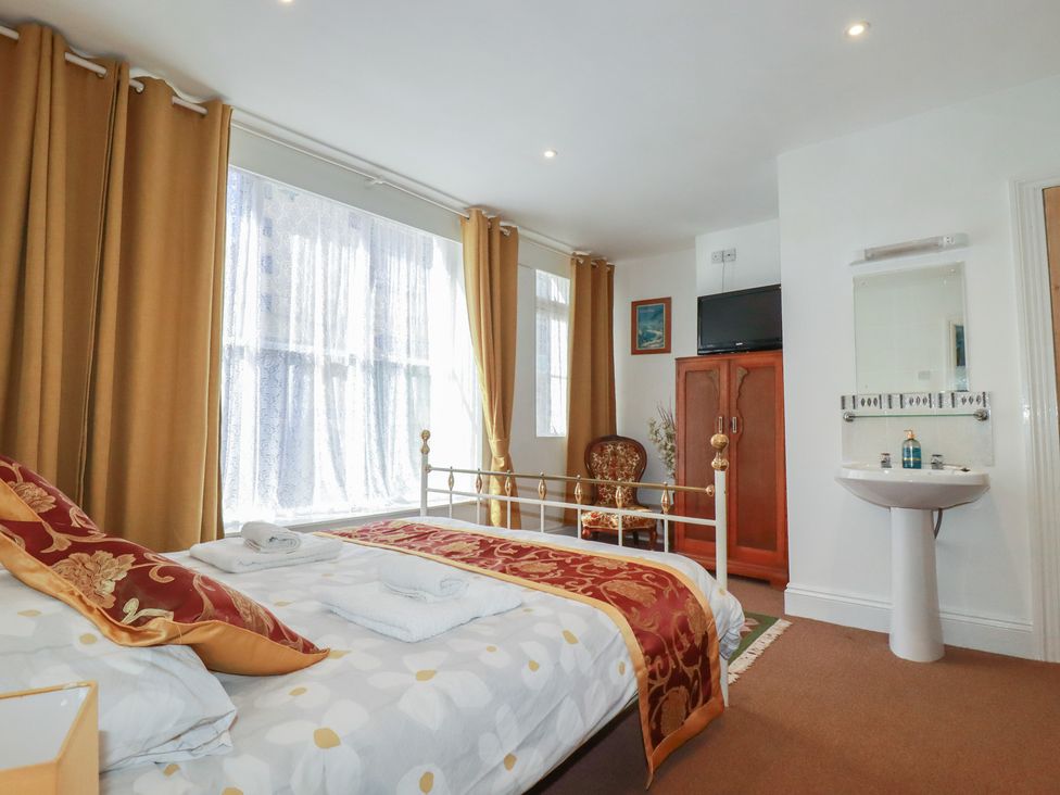 A bedroom with a bed and a chair at The Old Bank House in Mevagissey