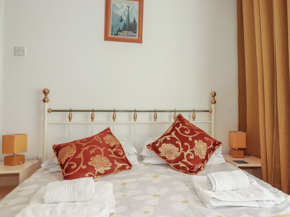A bedroom with a bed and decorative pillows at The Old Bank House in Mevagissey