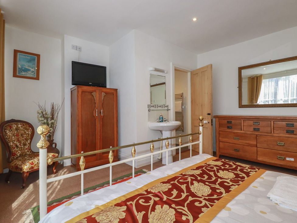 A bedroom with a bed and a dressing table at The Old Bank House Mevagissey