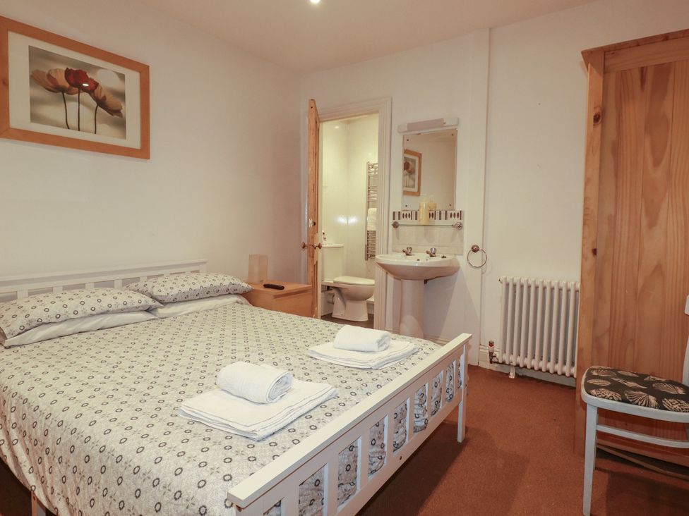 A bedroom with a bed and adjacent bathroom at The Old Bank House in Mevagissey