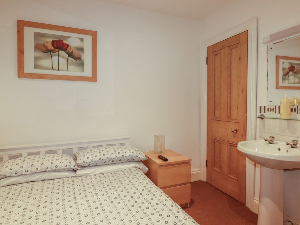 A bedroom with a bed and nightstand at The Old Bank House in Mevagissey