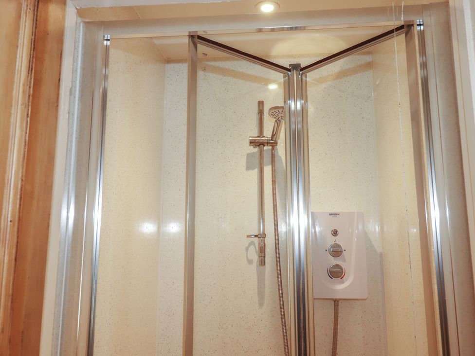 A shower with glass doors and a control panel at The Old Bank House in Mevagissey
