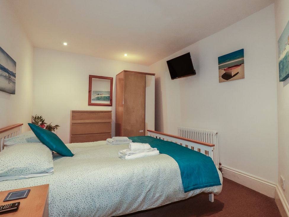 A bedroom with a bed and wardrobe at The Old Bank House in Mevagissey