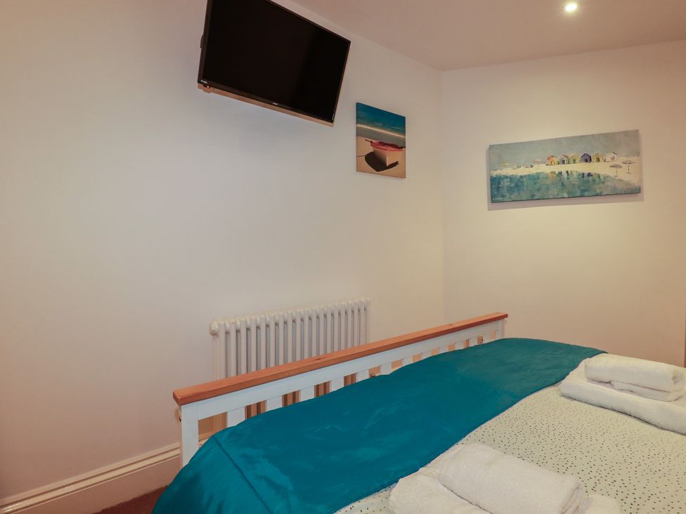 A bedroom with a bed and TV at The Old Bank House in Mevagissey