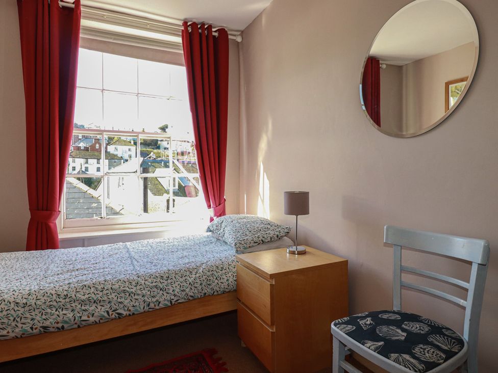 A bedroom with a bed and bedside table at The Old Bank House in Mevagissey