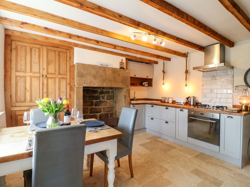 A kitchen with a table and chairs at 2 Knoll Mount in Matlock