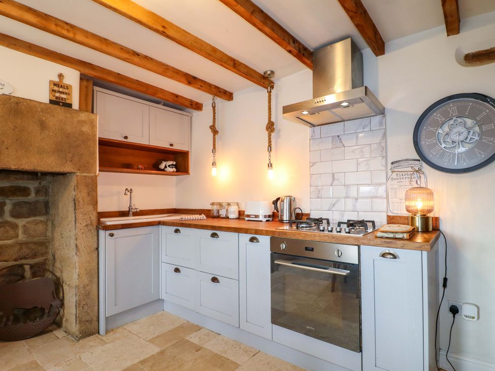 A kitchen with a sink and stove at 2 Knoll Mount in Matlock