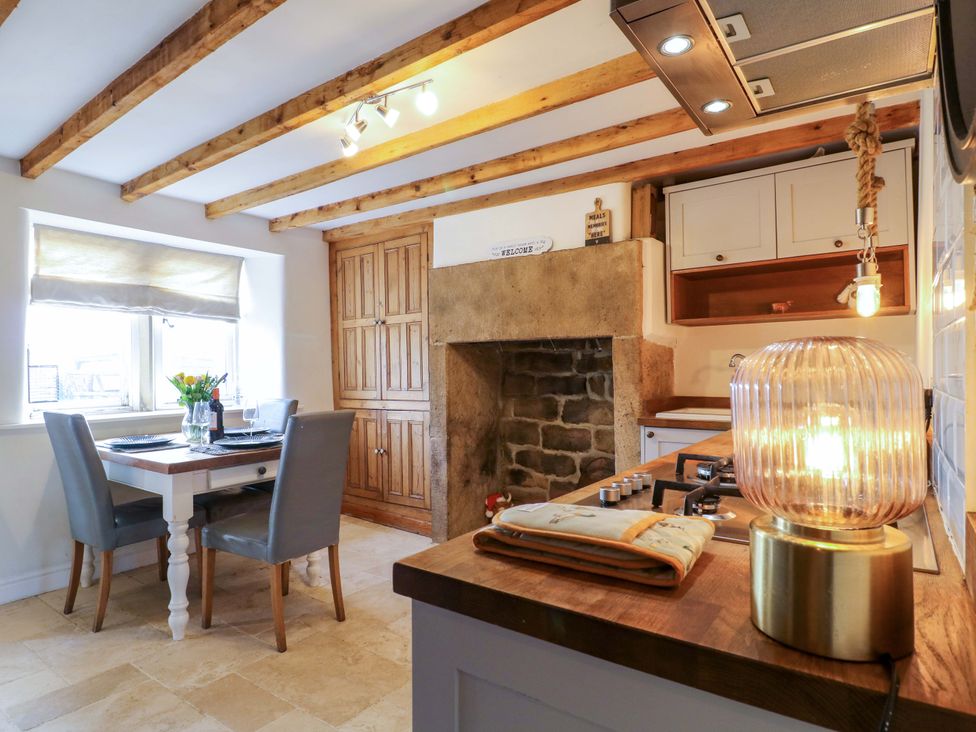 A kitchen with a dining table and chairs at 2 Knoll Mount in Matlock