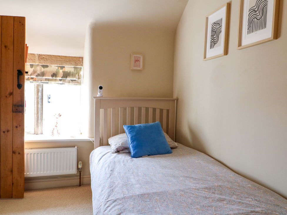 A bedroom with a bed and window at 2 Knoll Mount in Matlock