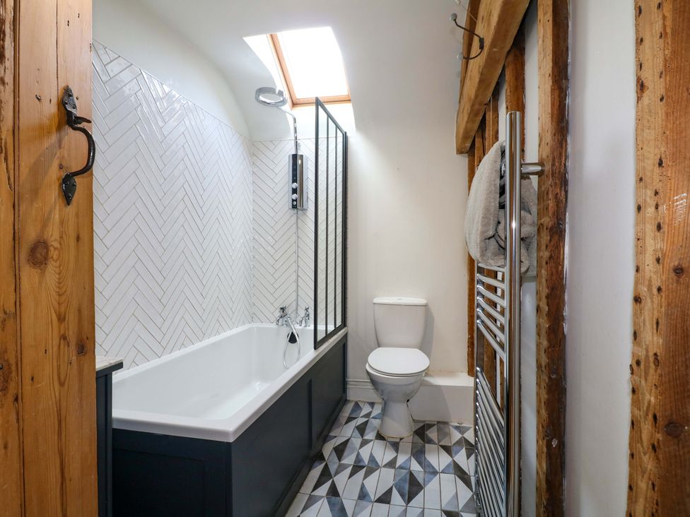 A bathroom with bathtub and shower at 2 Knoll Mount in Matlock