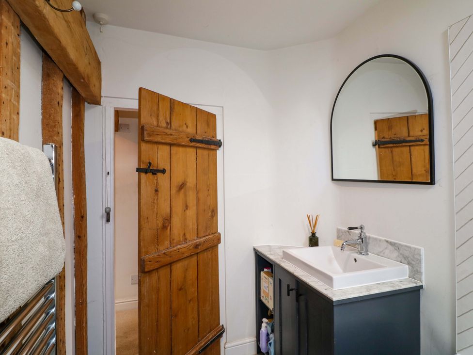 A bathroom with a sink and a wooden door at 2 Knoll Mount Matlock