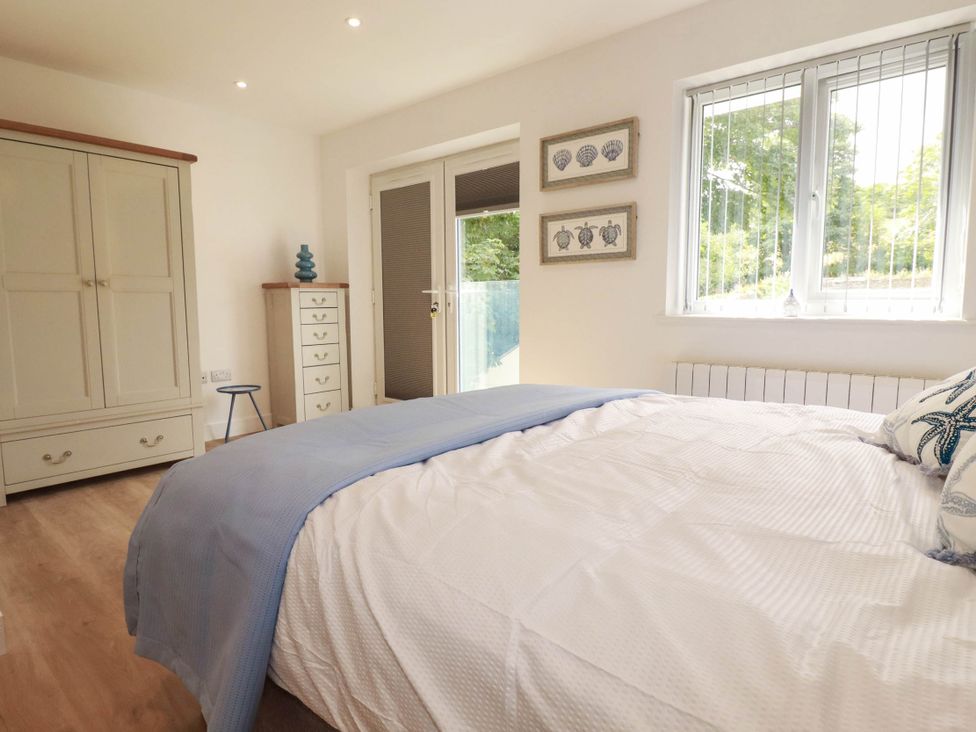 A bedroom with a bed and a wardrobe at Creek Lodge in Chacewater