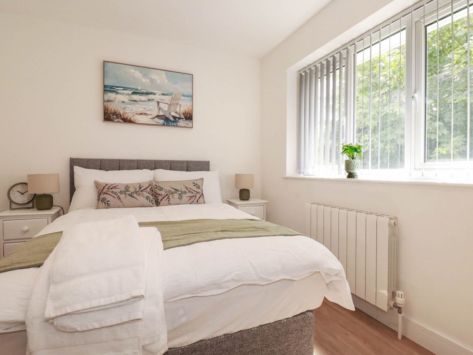 A bedroom with a bed and nightstands at Creek Lodge Chacewater