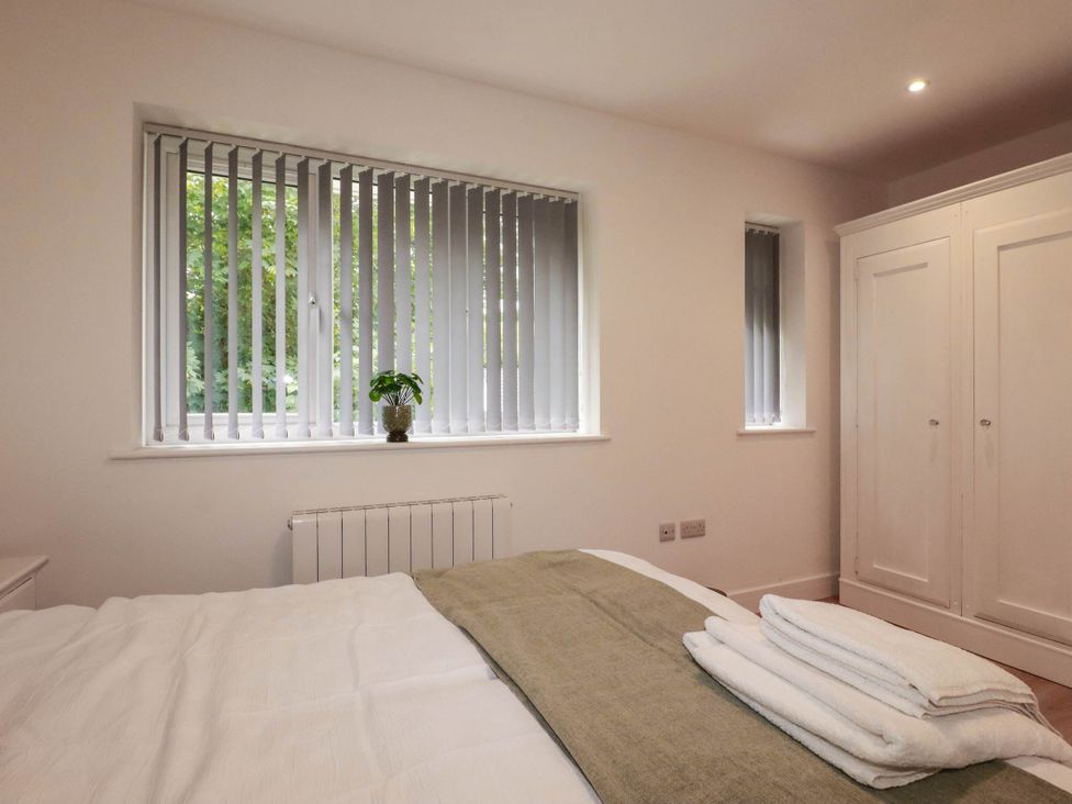 A bedroom with a bed and window at Creek Lodge Chacewater