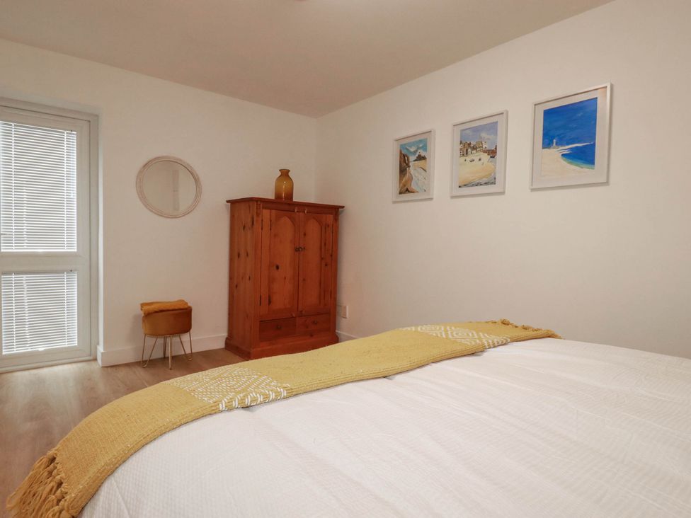 A bedroom with a wardrobe and artworks on the wall at Creek Lodge in Chacewater