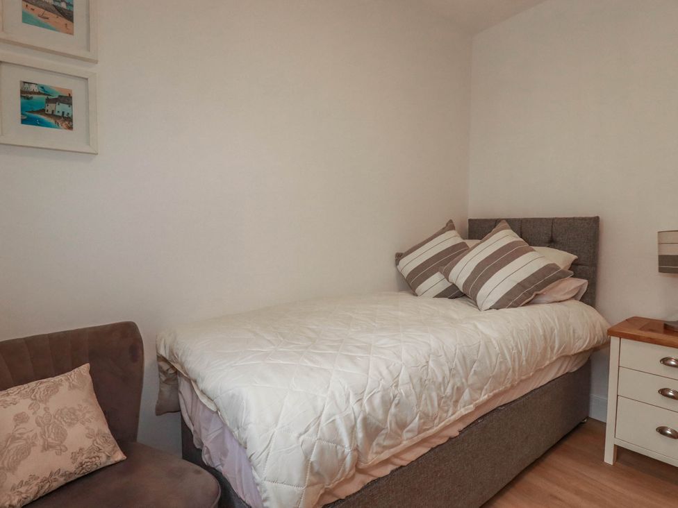 A bedroom with a bed and chair at Creek Lodge in Chacewater