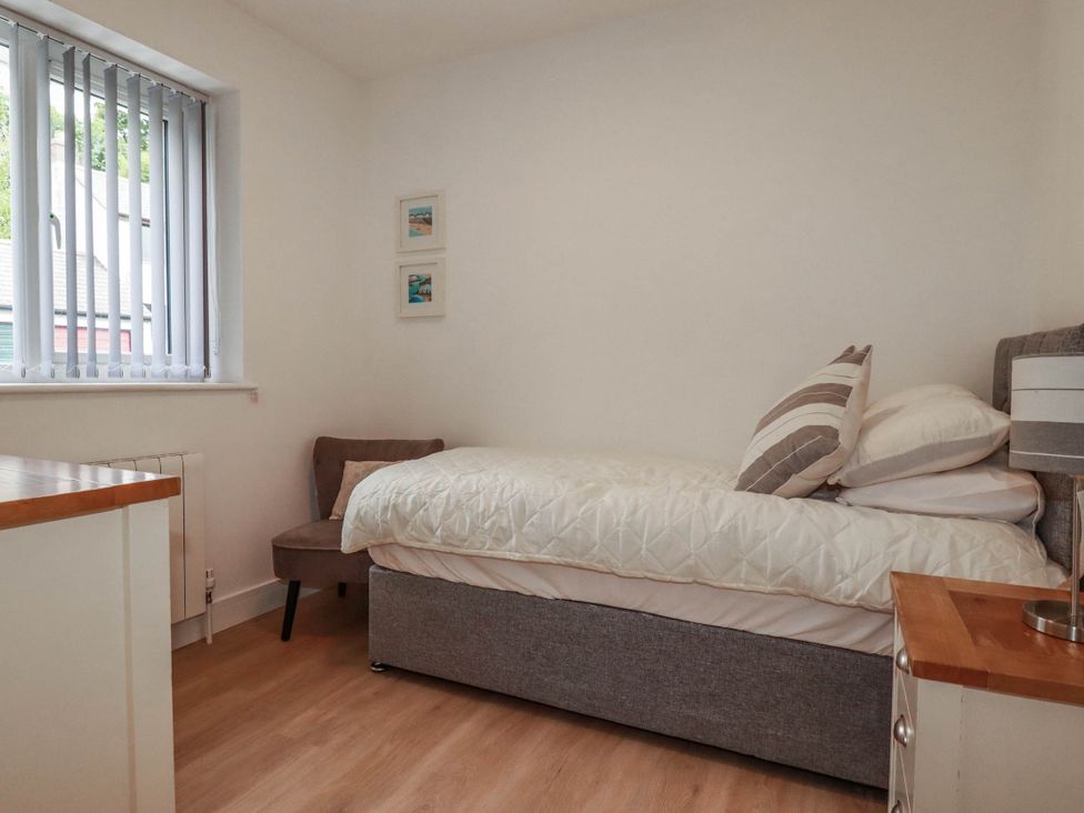 A bedroom with a bed and a chair at Creek Lodge in Chacewater