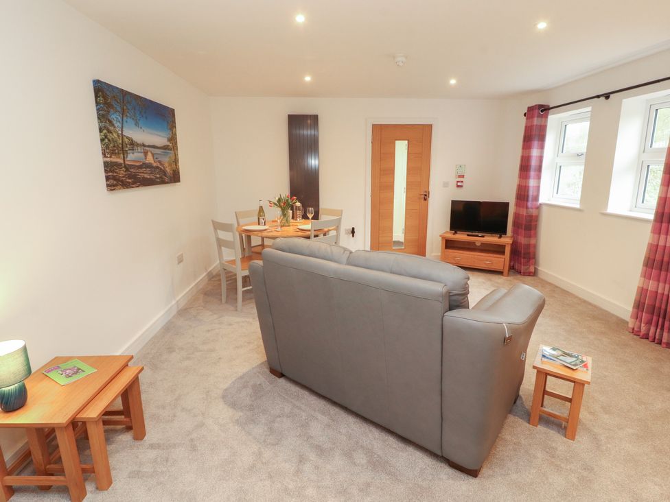 A living room with a dining area and a television at Little Plum Tree in Milnthorpe