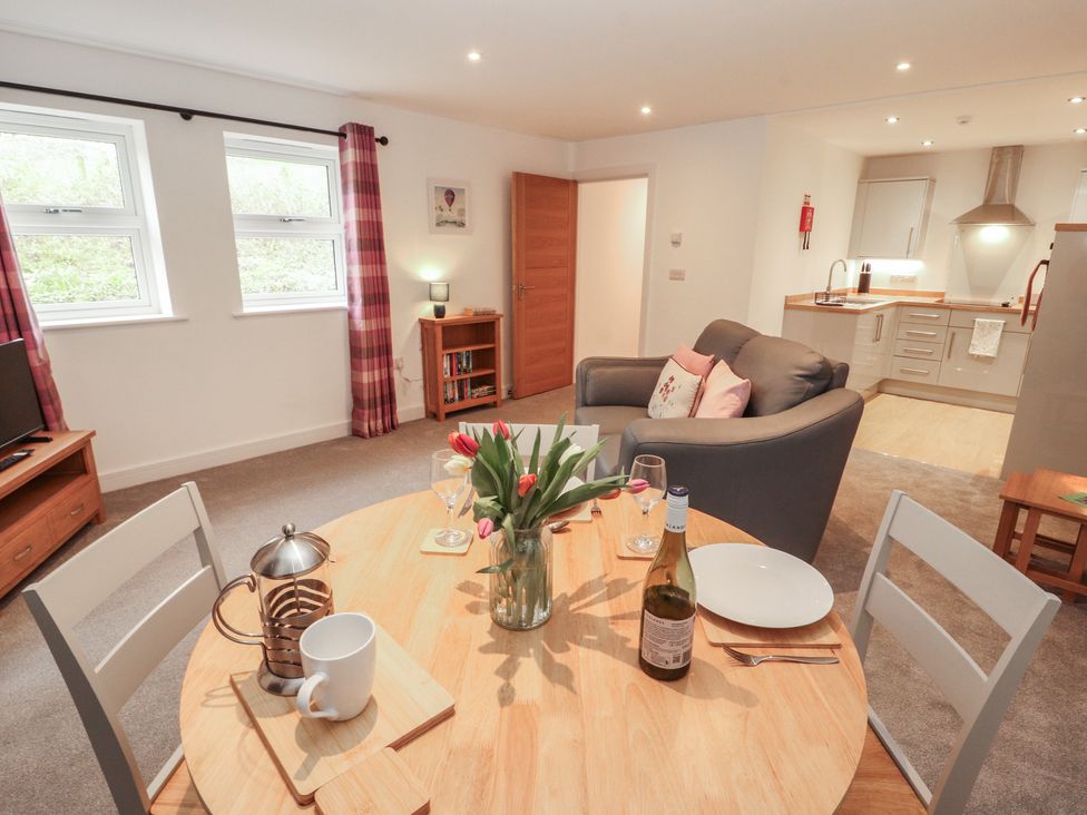 A living room with a dining table and sofa at Little Plum Tree in Milnthorpe