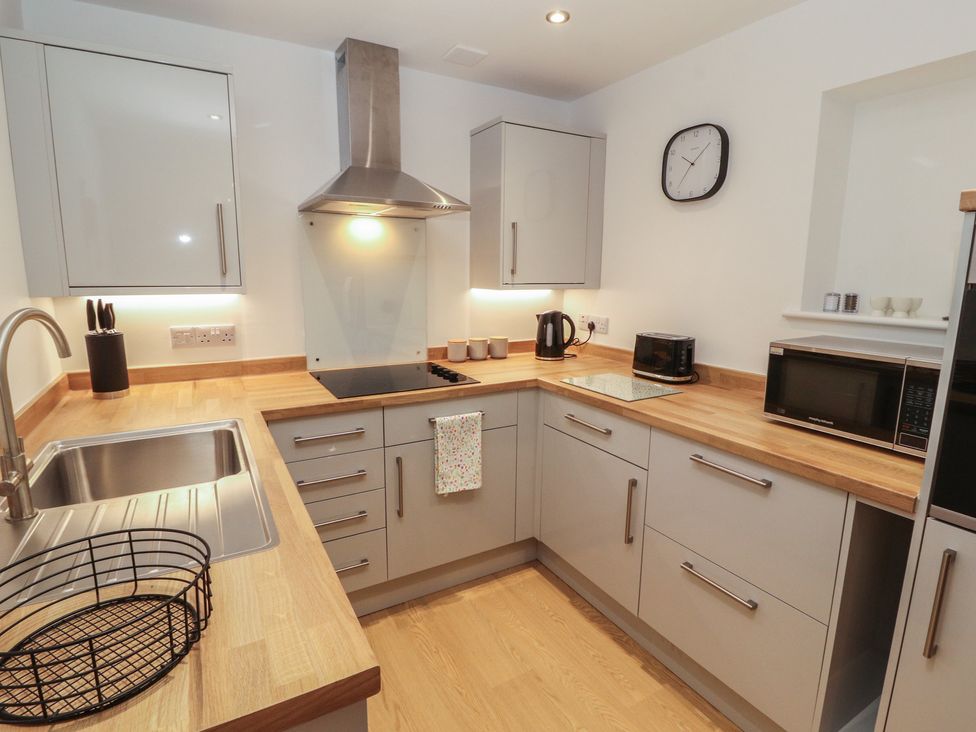 A kitchen with cabinets and appliances at Little Plum Tree in Milnthorpe