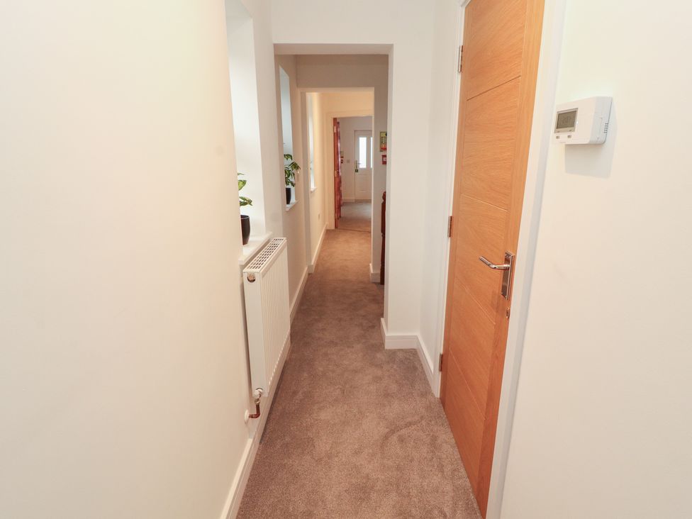A hallway with a door and radiator at Little Plum Tree in Milnthorpe