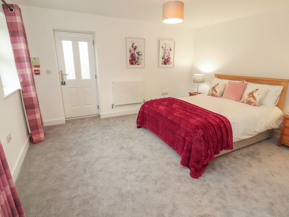 A bedroom with a bed and bedside table at Little Plum Tree in Milnthorpe