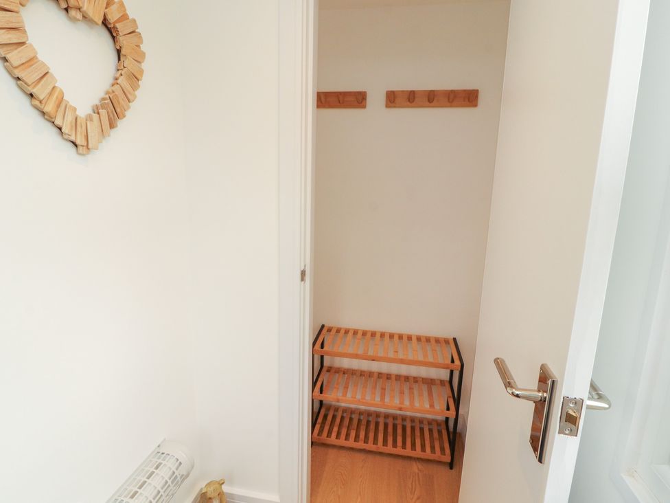 A closet with wooden shelving and hooks at Little Plum Tree in Milnthorpe