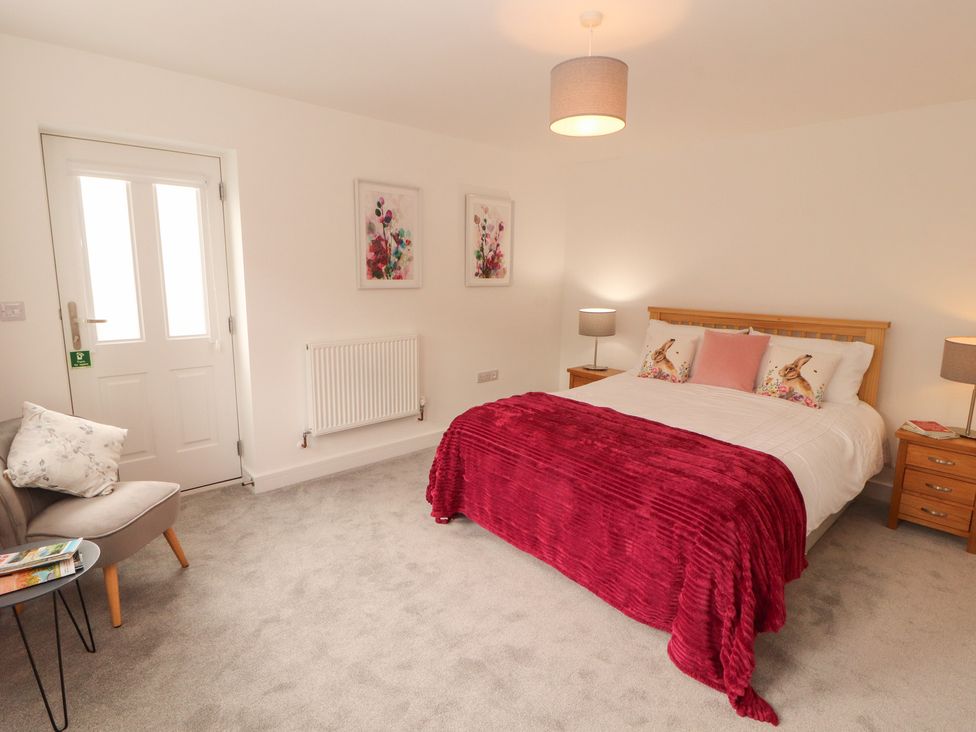 A bedroom with a bed and nightstand at Little Plumtree in Milnthorpe
