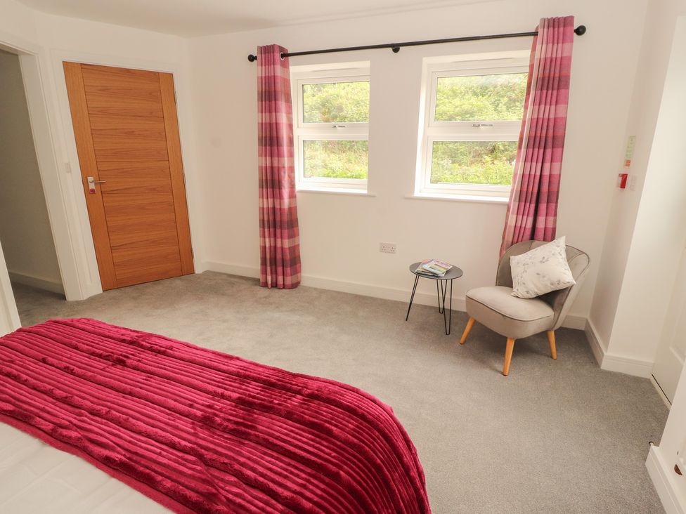 A bedroom with a bed and a chair at Little Plumtree in Milnthorpe