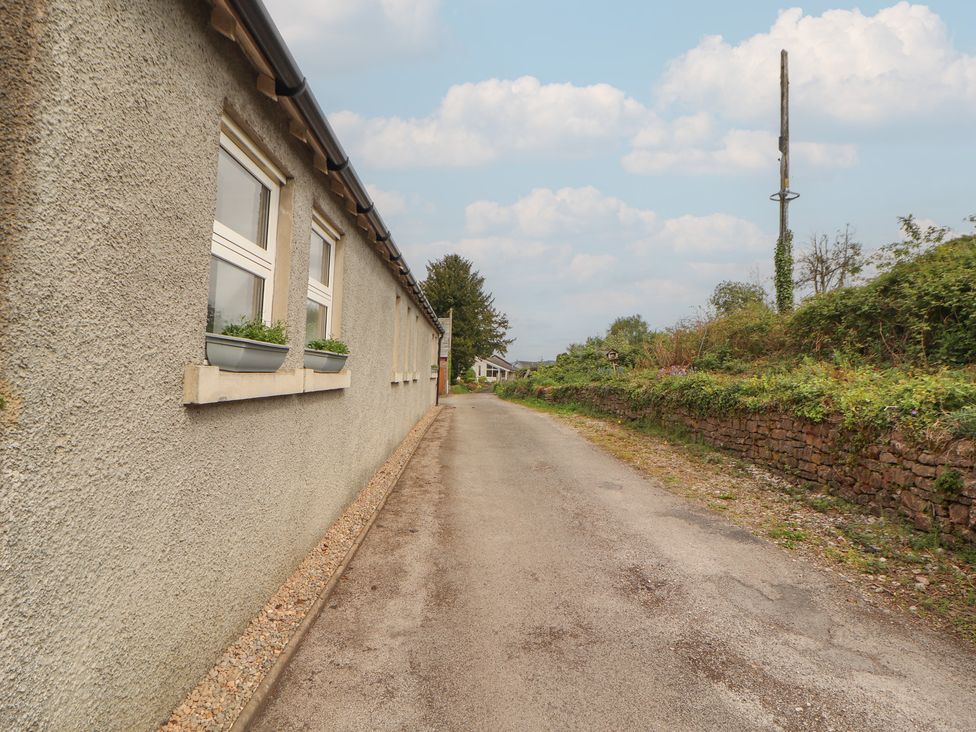 A pathway alongside a building with windows at Little Plumtree in Milnthorpe