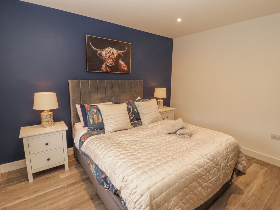 A bedroom with a bed and nightstands at Blue heron lodge Kirkby Stephen