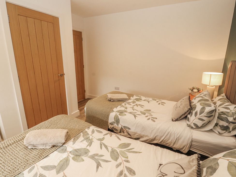 A bedroom with twin beds and a lamp at Blue heron lodge in Kirkby Stephen