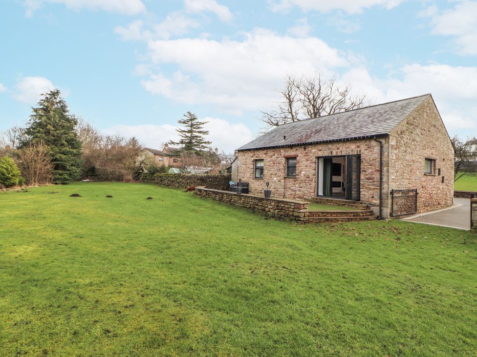 An outdoor area with a building and grass at Blue heron lodge in Kirkby Stephen