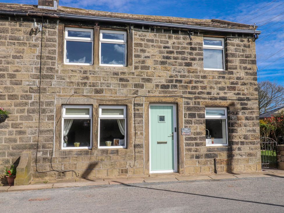 A stone house with a blue door and windows at Vasey Croft Stanbury near Haworth