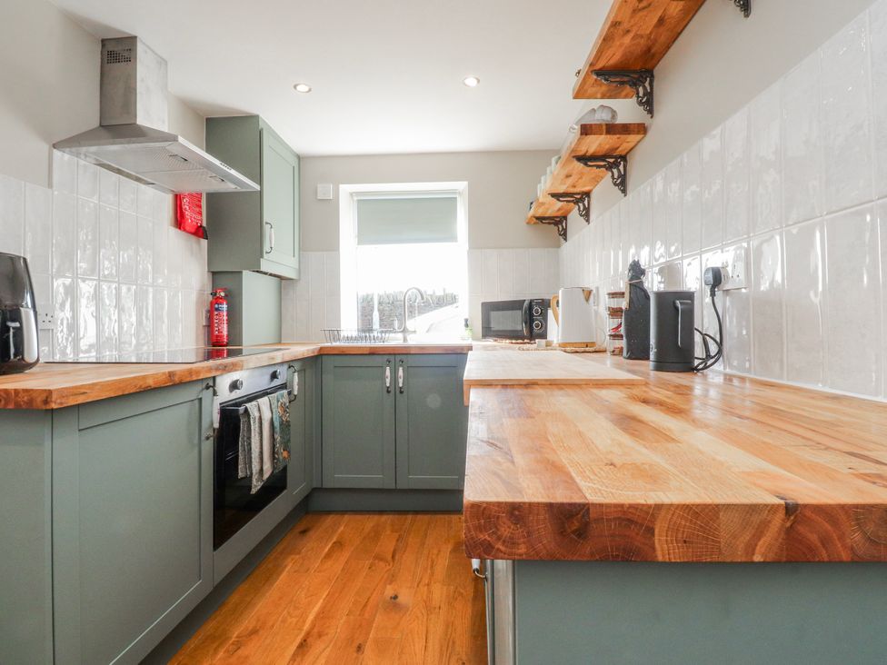 A kitchen with a countertop, cabinets, and appliances at Vasey Croft in Stanbury near Haworth