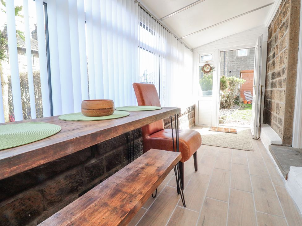 A conservatory with a table and chairs at Vasey Croft in Stanbury near Haworth
