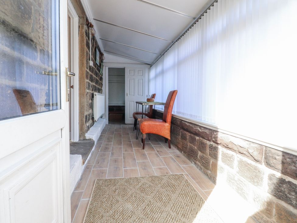 A conservatory with a table and chairs at Vasey Croft in Stanbury near Haworth
